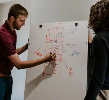 man drawing on dry-erase board